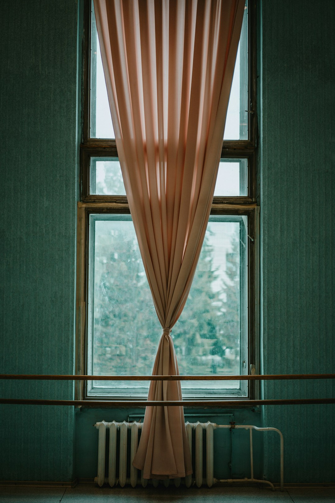 Large window with sheer curtains and natural light in a studio