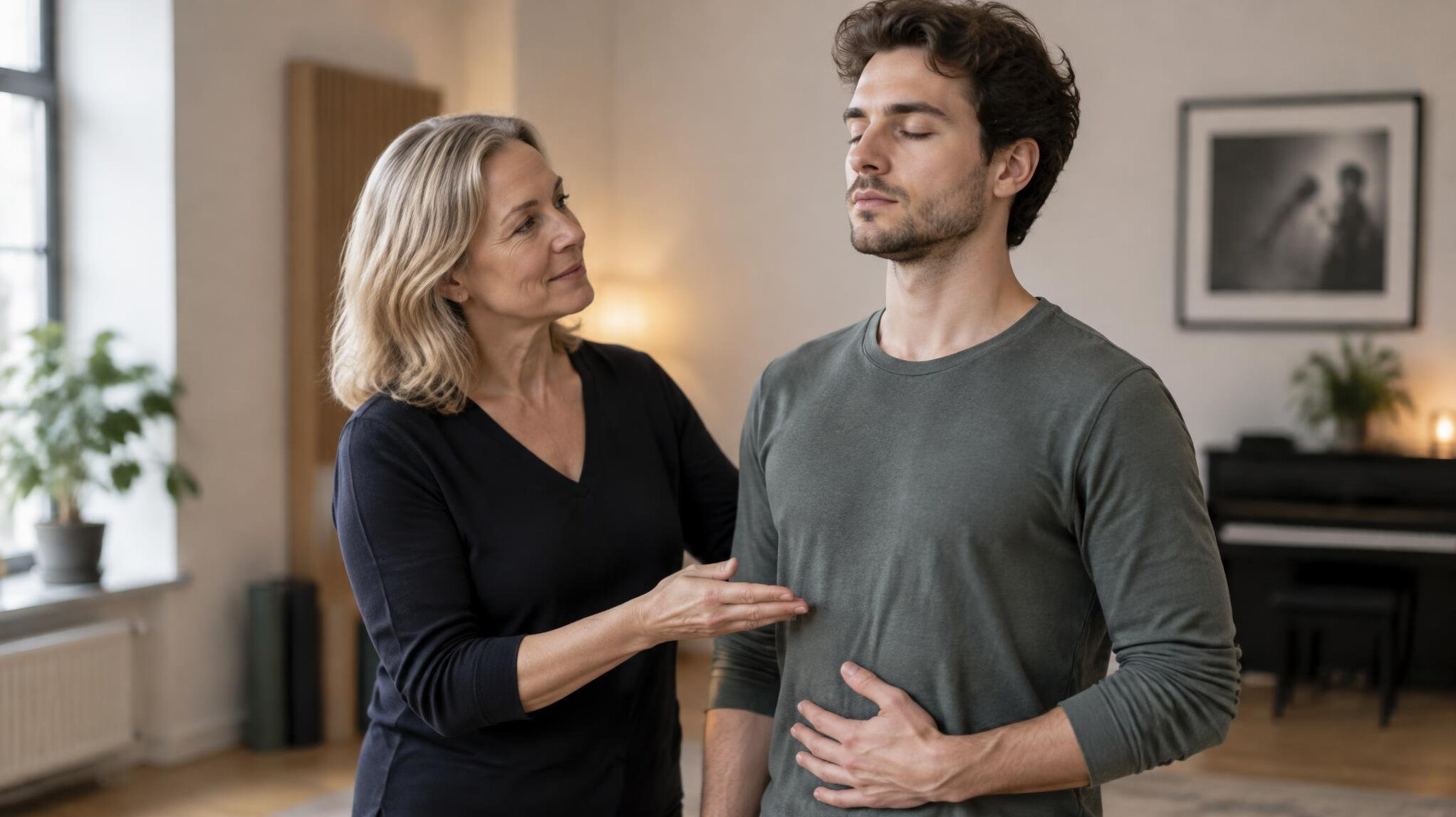 Voice coach guiding a student during a breathing exercise in a calm studio